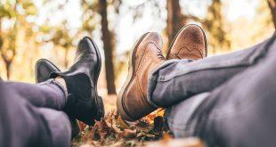 Zwie Personen liegen in herbstlichem Park auf dem Boden. Man sieht die Beine und Schuhe.