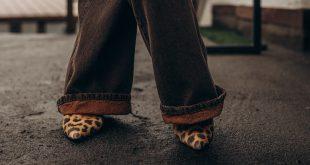 Frau mit weiten, braunen Hosen und Schuhen mit Leo-Print