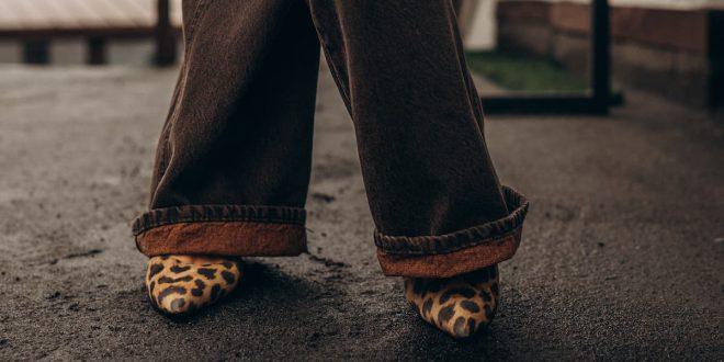 Frau mit weiten, braunen Hosen und Schuhen mit Leo-Print