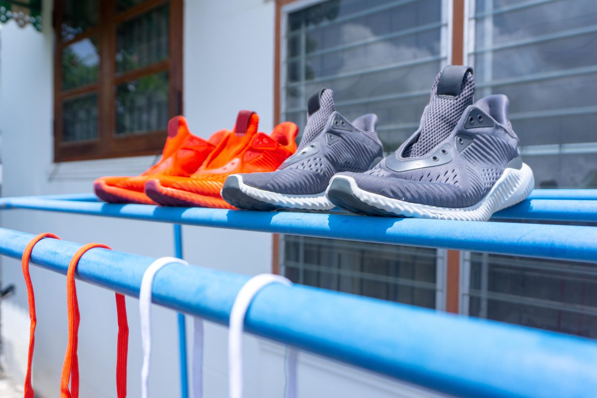 Zwei Paar Schuhe (orange und grau) trocknen in der Sonne