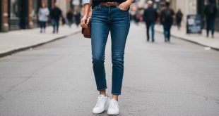 Junge Frau trägt weiße Ralph Lauren Sneaker mit Jeans und blauem Pullover in urbaner Umgebung